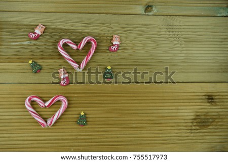 Christmas food photography picture of peppermint red white stripe candy canes with iced decorations in background on natural wood. Studio image taken on South coast England UK