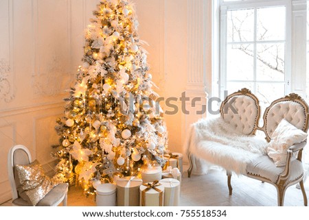 luxurious expensive light interior living room in a royal style decorated with a Christmas tree and large windows
