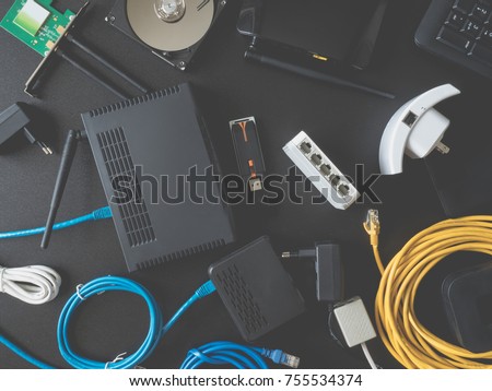 top view of Computer Network Devices concept with Hub, Switch, Router, Modem, wireless repeater,  wireless card, lan cable, USB wifi adapter on black table background