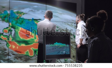 Group of scientists investigating hurricane as consequence of global warming on earth. Elements of this image furnished by NASA. Royalty-Free Stock Photo #755538235