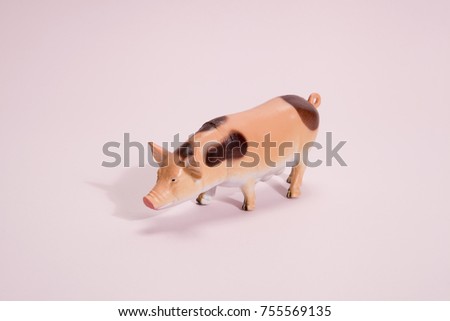 pink pig plastic figurine toy on a vibrant pink background. Minimal still life photography