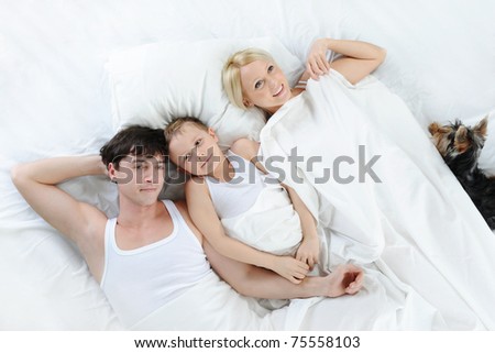 Happy family lying in bed in the morning.