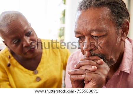 Senior Woman Comforting Man With Depression At Home Royalty-Free Stock Photo #755583091