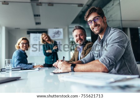 Happy group of businesspeople during presentation. Colleagues looking at camera and smiling. Royalty-Free Stock Photo #755621713