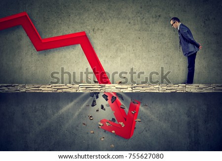Curious worried business man looking down at the falling red arrow going through a concrete floor. Royalty-Free Stock Photo #755627080