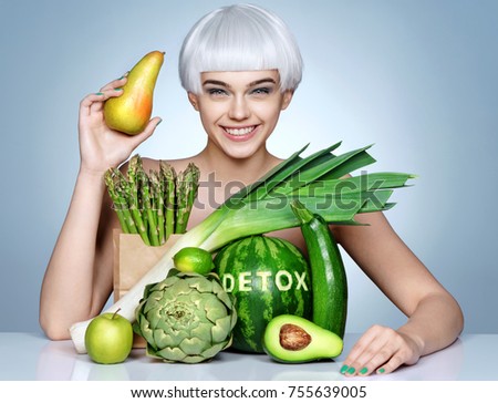 Fashion girl with an abundance of fruits and vegetables. Photo of smiling blonde girl holding pear. Healthy lifestyle concept
