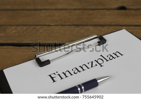 Finanzplan (german for financial plan) - right close up with a pen