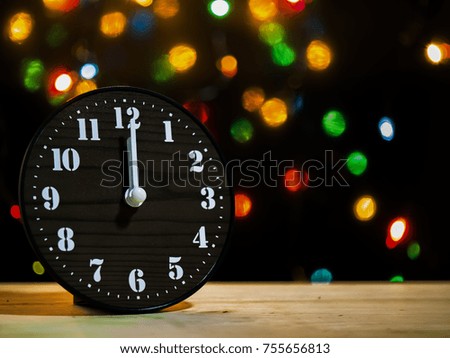 Light bokeh with a black background on Christmas night at midnight and clock.
