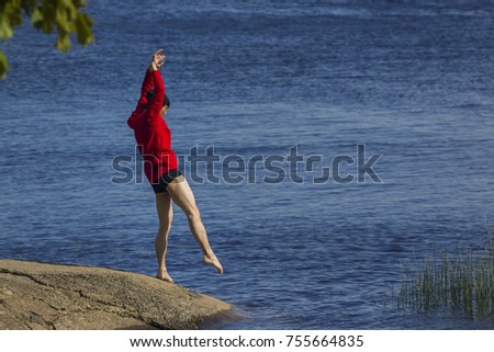 Portrait of young and fit chinese contemporary dancer, performing next to the lake. Conceptual photo - connection of the human and nature.