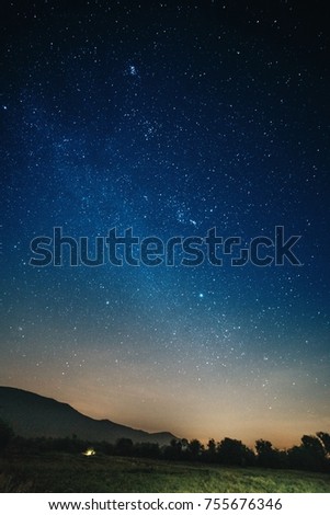 Star in the night sky with silhouette mountain and forest  