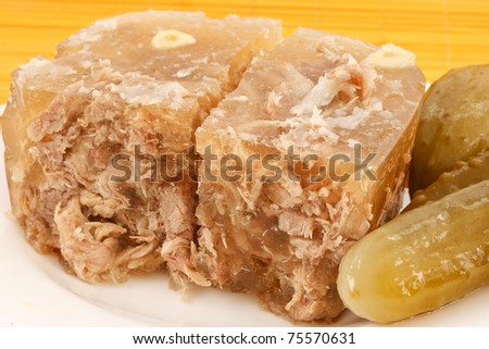 meat jelly on a plate with pickles