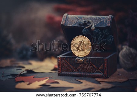 Gold bitcoin. Treasures - crypto currency mysterious autumn leaves. Old wooden box Virtual money on a dark background. warm toning.
