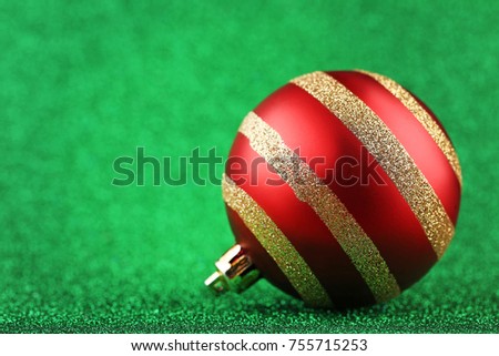 Red christmas bauble on green background