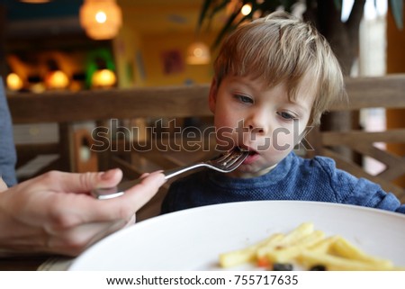 Mother feeding her son in a restaurant