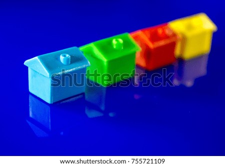 A blue background with plastic houses as the main focus.