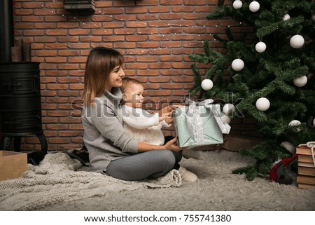 Mother and daughter by the Christmas tree