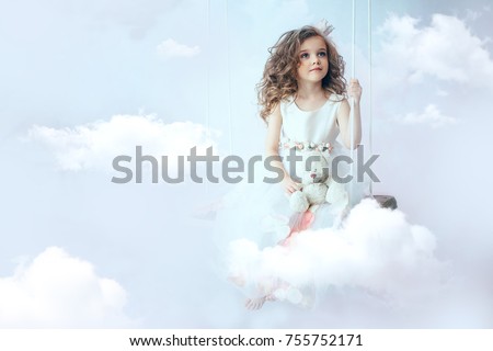 little girl is sitting on the cloud