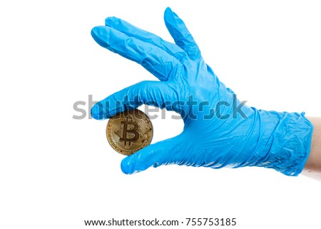 Hand with blue, medical gloves holding a golden bitcoin