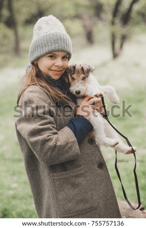 Girl playing with a dog fox terrier. Outdoor