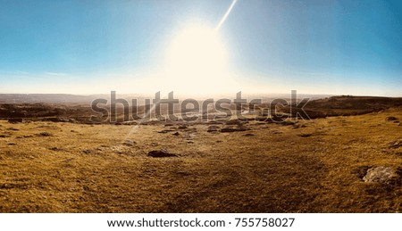 Bright sun and sun beam panoramic view over moorland with a deep blue sky in Autumn