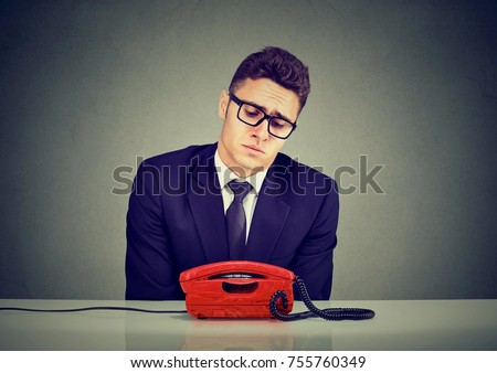 Desperate sad business man waiting for someone to call him  Royalty-Free Stock Photo #755760349