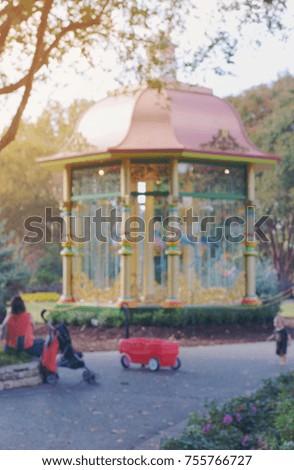 blurry picture of family stopping at gazebo and flowers at park, filtered tones