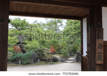 The view through the wooden gates in Koko-en Garden, Himeji, Japan, with the entrance sign on the right which translates as "Pine Garden"