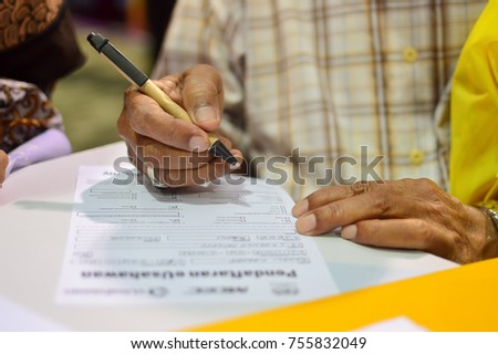 Closeup of human hand writing on a paper.
