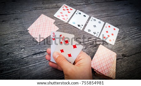 Apzart board gambling game poker male hand holding card three of hearts and six of diamonds, on the table layout playing cards - street