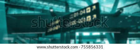 A blur picture of english and arabian yellow illuminated sign at airport with gate letters for departing flights. For background use. 