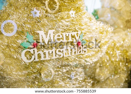 Close up of decoration Merry Christmas decorated on golden  Christmas tree or pine with defocused blurred lights bokeh background and copy space. Picture for Xmas eve and happy new year concepts.