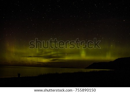 The northern lights dancing in the sky over the sleeping bear dunes national lake shore and lake michigan