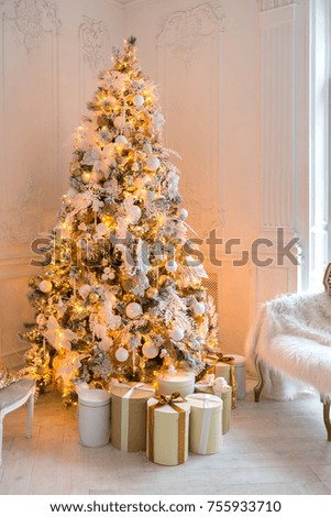luxurious expensive light interior living room in a royal style decorated with a Christmas tree and large windows