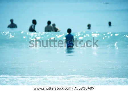 Little child staying up in the sea ,blurry picture landscape blue sea background