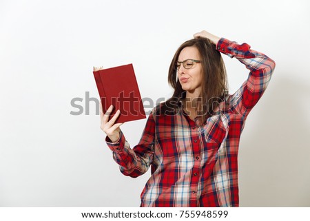 A beautiful European young brown-haired woman in glasses for sight with healthy clean skin dressed in casual red plaid shirt, standing with the book on a white background. Reading and studying concept