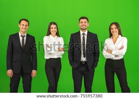 The four business people stand on the green background