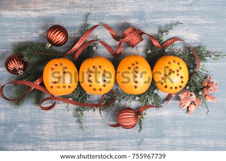 Christmas oranges with figures 2018. Fruits on wooden background. Red tape and bauble, fir-tree branches 