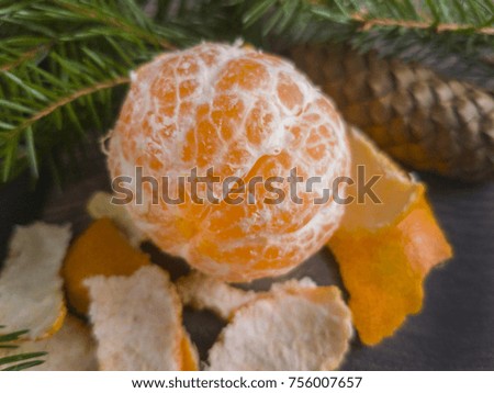 mandarin and cones and green twigs on a wooden background