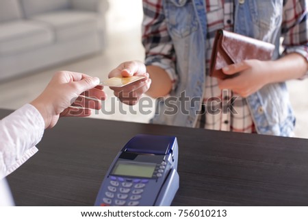 Customer giving credit card to cashier indoors