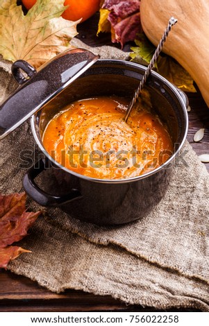 Image of soup puree in saucepan, pumpkin on linen cloth