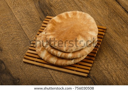 Pita bread heap over the wooden background
