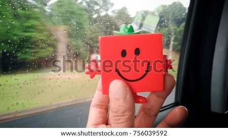 close up image of hand holding toy with happy smiley