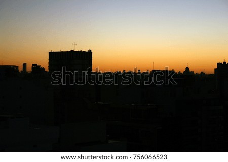 the buildings with the orange sun behind, backlight