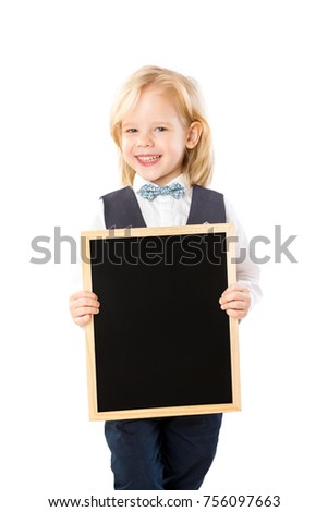 Closeup portrait of cute smiling boy in suit holding black board isolated at white background.
