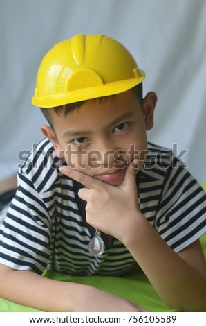 asian boy and construction hat are pose hansomely in his picture