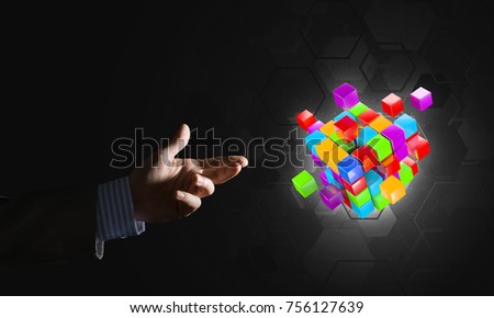 Close of businessman hand holding cube figure as symbol of innovation, mixed media
