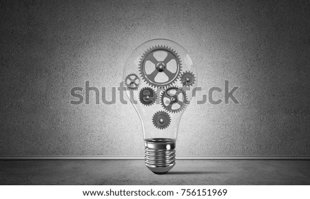 Glass lightbulb with multiple gears inside placed in empty room with grey wall on background. 3D rendering.