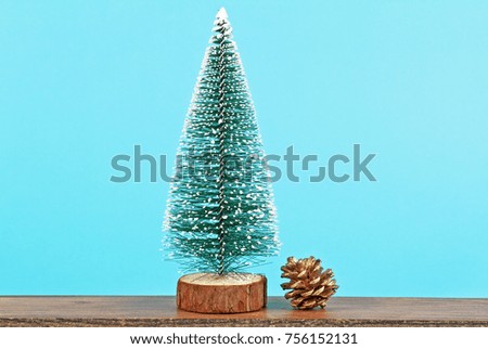 Christmas tree and golden pine cone on blue background