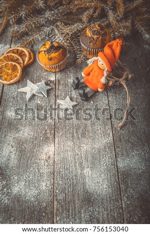 Xmas or new year composition with holiday decoration - Homemade X-mas cupcakes on wooden background. Sledge, little man figures. Christmas card. Space for text, toned instagram, top view