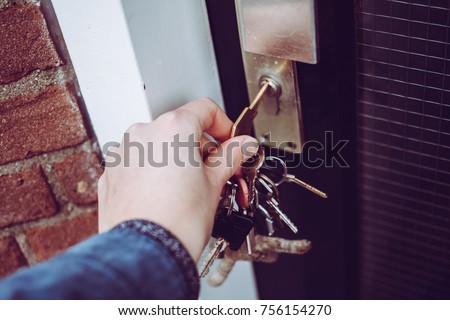 Hand opening house door with bunch of keys Royalty-Free Stock Photo #756154270